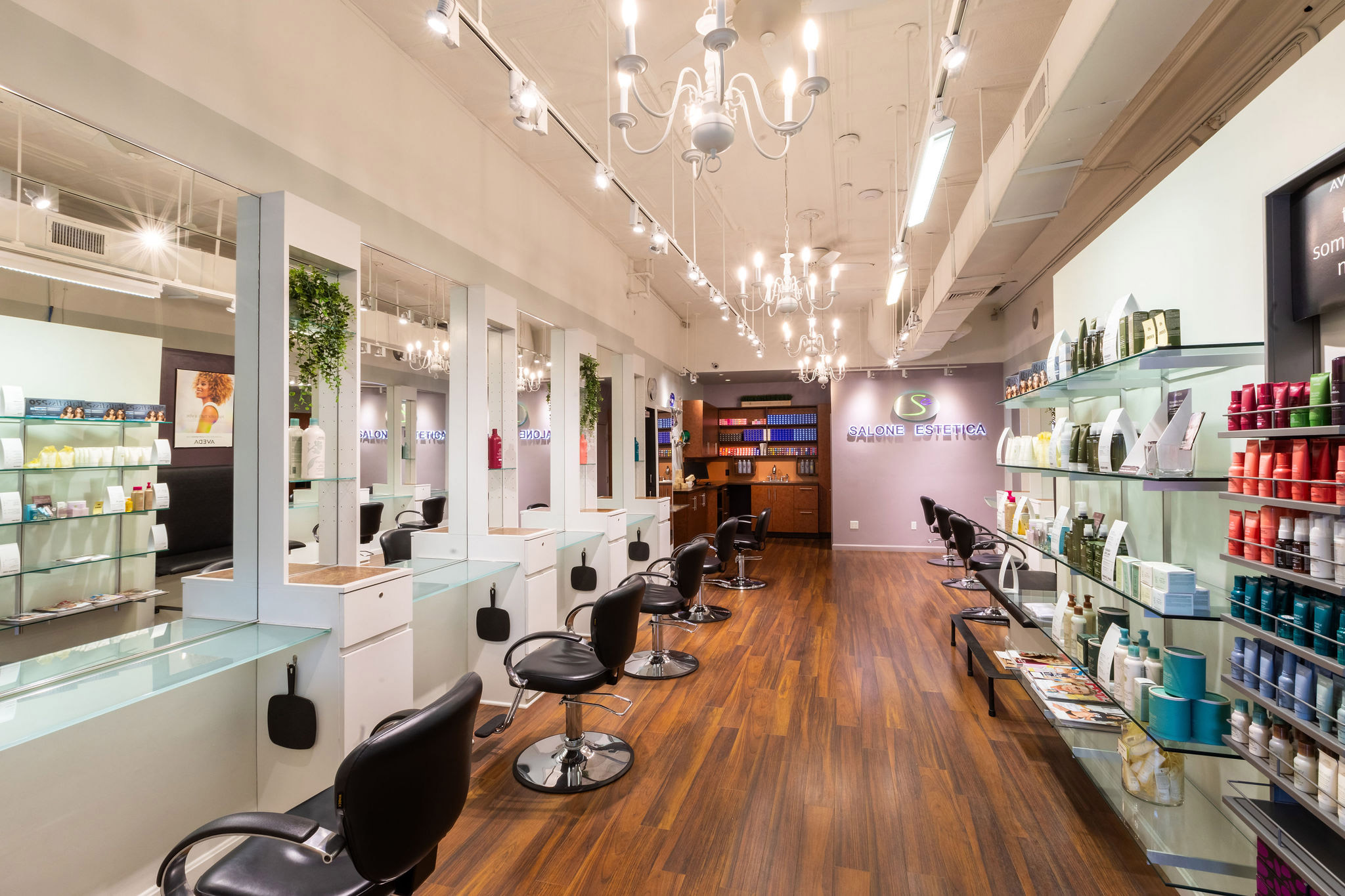 - Salone Estetica in Winchester, MA Modern Aveda salon interior with empty black chairs, mirrors, shelves of hair products, wood flooring, and ceiling chandeliers—perfect for wedding hair and makeup or anyone seeking the best salon experience. - Salone Estetica in Winchester, MA